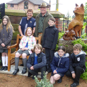 St. Helen's School children visit the cemetery and join local residents in the fox sculpture corner - just one of several improved areas in the cemetery.