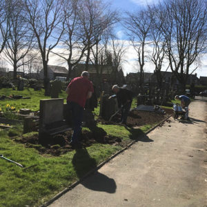 Following memorial improvements volunteers weed and prepare the ground for grass seeding.