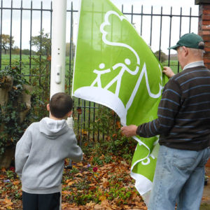 The Friends youngest and oldest volunteers raise the Green Flag.