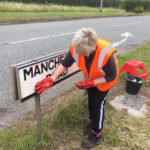 Community Plan volunteer helps at the sign cleaning action day Hollins Green - 1st June 2019.